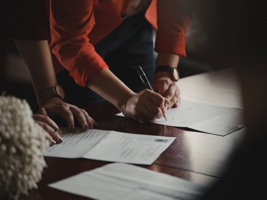 Woman signing legal documents at a table